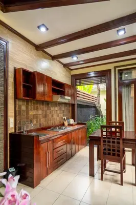 a kitchen with wooden cabinets and a wooden table and a tableablish at The Bali Dream Suite Villa Seminyak in Seminyak