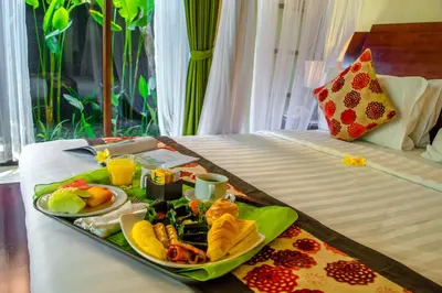a tray of breakfast food on a bed at The Bali Dream Suite Villa Seminyak in Seminyak