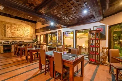 a dining room with wooden tables and chairs at The Bali Dream Suite Villa Seminyak in Seminyak
