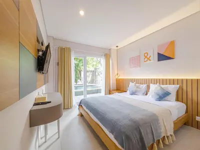 a bedroom with a large bed and a window at Hola Seminyak in Seminyak