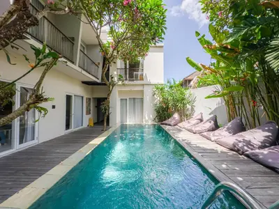 a swimming pool in the middle of a building at Hola Seminyak in Seminyak
