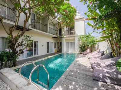 a swimming pool in front of a building at Hola Seminyak in Seminyak