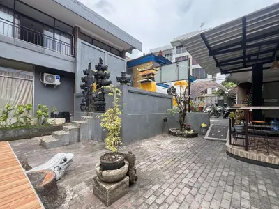 a courtyard with a building and some trees and buildings at RedDoorz at Mahendra Beach Inn Kuta in Kuta