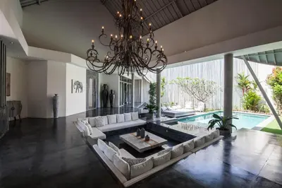 a living room with a large couch and a chandelier at Villa Xaloc by House of Winds - Stunning Balinese retreat next to Canggu in Kerobokan