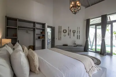 a white bedroom with a large bed and a chandelier at Villa Xaloc by House of Winds - Stunning Balinese retreat next to Canggu in Kerobokan