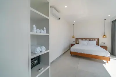 a bedroom with white walls and a bed in a room at Villa Vantage 7 - Outstanding 3 BR Villa - Great Location! in Canggu
