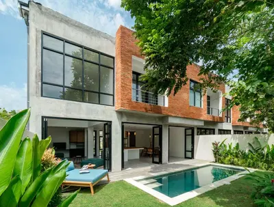 a brick house with a pool in the backyard at Umalas Living Villa in Canggu