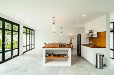 a kitchen and living room with white walls and windows at Umalas Living Villa in Canggu