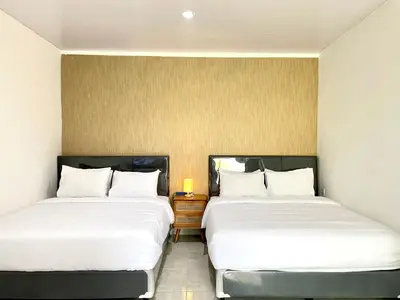 two beds sitting next to each other in a room at Satran Villa @ Kuta Bali in Legian