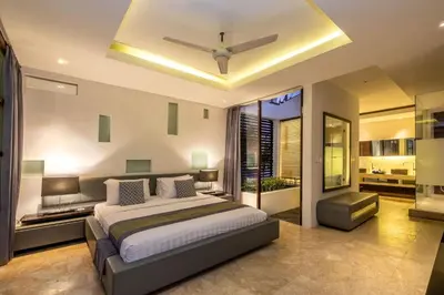 a bedroom with a large bed with a ceiling at Villa Aqua Seminyak in Seminyak