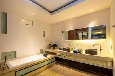 a bathroom with a large tub and a sink at Villa Aqua Seminyak in Seminyak
