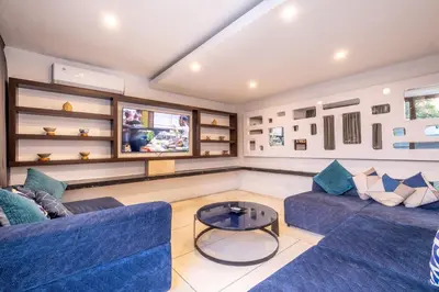 a living room with two blue couches and a table at Villa Aqua Seminyak in Seminyak