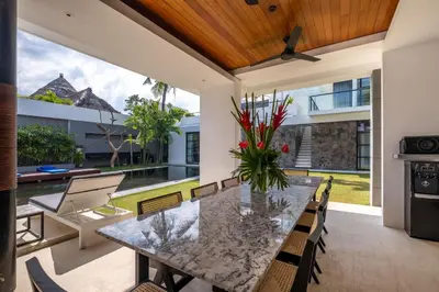 an outdoor dining room with a table and chairs at Villa Aqua Seminyak in Seminyak