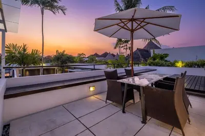 an outdoor patio with a table and an umbrella at Villa Aqua Seminyak in Seminyak