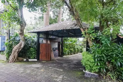 a small building with a gate and a tree at Kos 168 Jimbaran in Jimbaran