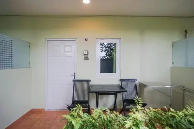 a porch with a table and two chairs and a door at Kos 168 Jimbaran in Jimbaran