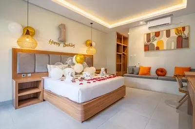 a bedroom with a large bed with red flowers on it at Casa Wina Kuta by The Wina Resorts in Kuta