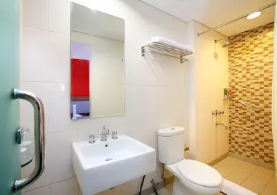 a bathroom with a sink and a toilet and a mirror at Amaris Hotel Dewi Sri - Bali in Legian