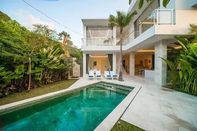 a swimming pool in front of a house at Fantastic 3 Bed Villa, Walk to Beach, Sunny Pool in Seminyak