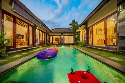a swimming pool with two inflatable boats in front of a house at 4BR w/ Pool- Ultimate Comfort in Umalas in Kerobokan