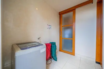 a laundry room with a washing machine and a door at 4BR w/ Pool- Ultimate Comfort in Umalas in Kerobokan