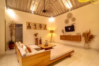 a living room with a couch and a tv at Simple & Magical Villas PRAYA in Seminyak