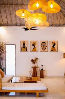 a living room with a table and yellow chandeliers at Simple & Magical Villas PRAYA in Seminyak
