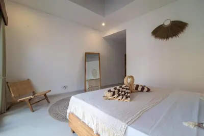 a bedroom with a bed and a mirror on the wall at Simple & Magical Villas. Villa Sambali llI in Seminyak