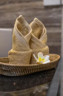 a pair of sandals sitting on a table with a flower at Simple & Magical Villas. Villa Sambali llI in Seminyak