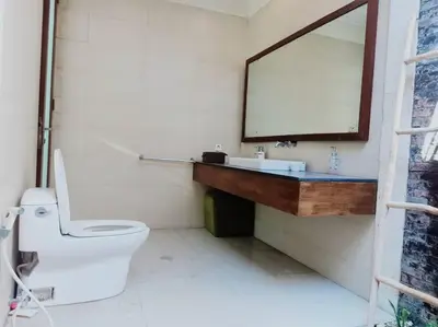 a bathroom with a white toilet and a mirror at Villa alula in Seminyak
