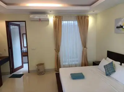 a bedroom with a white bed and a large window at Villa alula in Seminyak