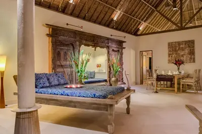 a bedroom with a bed and a living room at The Tirta Naga Villas in Seminyak