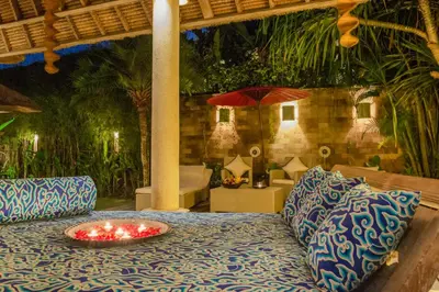 a table with a bowl of candles on top of it at The Tirta Naga Villas in Seminyak