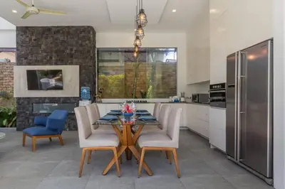 a kitchen with a table with chairs and a refrigerator at Villa Serenity: modern design luxury 12m pool and BBQ in Seminyak