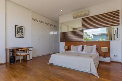 a bedroom with a bed and a desk and a window at Villa Serenity: modern design luxury 12m pool and BBQ in Seminyak