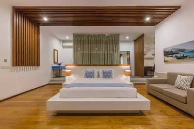 a bedroom with a large bed and a couch at Villa Serenity: modern design luxury 12m pool and BBQ in Seminyak