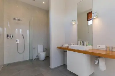 a bathroom with a shower and a sink and a toilet at Villa Serenity: modern design luxury 12m pool and BBQ in Seminyak