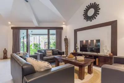 a living room with a couch and a table and a mirror at Villa Budha 2 4bedrs 12m Pool, 700m2 garden&BBQ, central & quiet in Seminyak