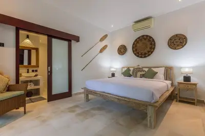a bedroom with a large bed and a chair at Villa Budha 2 4bedrs 12m Pool, 700m2 garden&BBQ, central & quiet in Seminyak