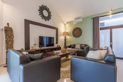 a living room with couches and a tv and a mirror at Villa Budha 2 4bedrs 12m Pool, 700m2 garden&BBQ, central & quiet in Seminyak