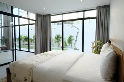 a bedroom with a large bed and large windows at Manresa Villa Bali 2 in Canggu