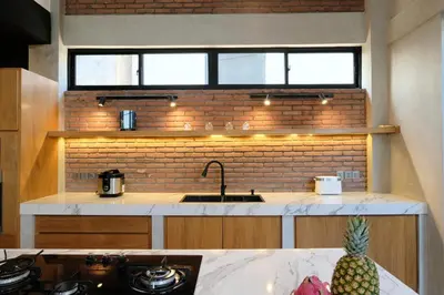 a kitchen with a sink and a brick wall at Manresa Villa Bali 2 in Canggu