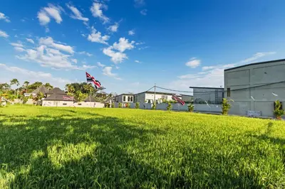 a field of green grass with two american flags at Manresa Villa Bali 2 in Canggu