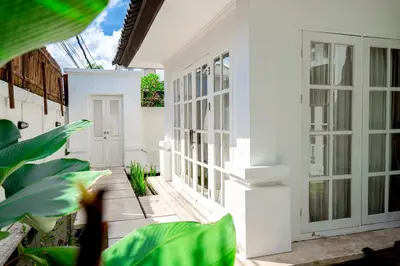 a white house with plants in the courtyard at Kencana Villa Seminyak in Seminyak