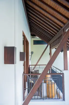 a stairway with a wooden roof and a balcony at The Kumpi Villas in Seminyak