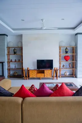 a living room with a couch with red pillows at The Kumpi Villas in Seminyak