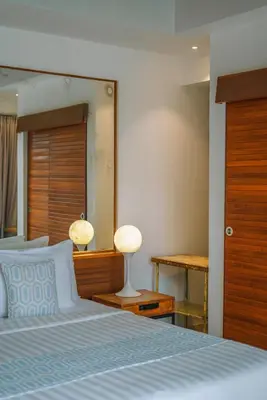 a bedroom with a large bed and a mirror at Villa Yasmee : Cozy and Modern 2 BR w/ Pool in Seminyak ! in Seminyak
