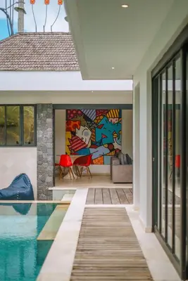 a house with a swimming pool with a painting on the wall at Villa Yasmee : Cozy and Modern 2 BR w/ Pool in Seminyak ! in Seminyak