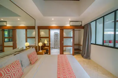 a bedroom with a large white bed and glass walls at Villa Anahata: Modern 2BR Villa w/ Pool in Seminyak ! in Seminyak