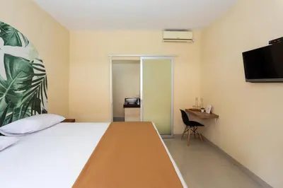 a hotel room with a bed and a television at Cove Kanaya in Denpasar
